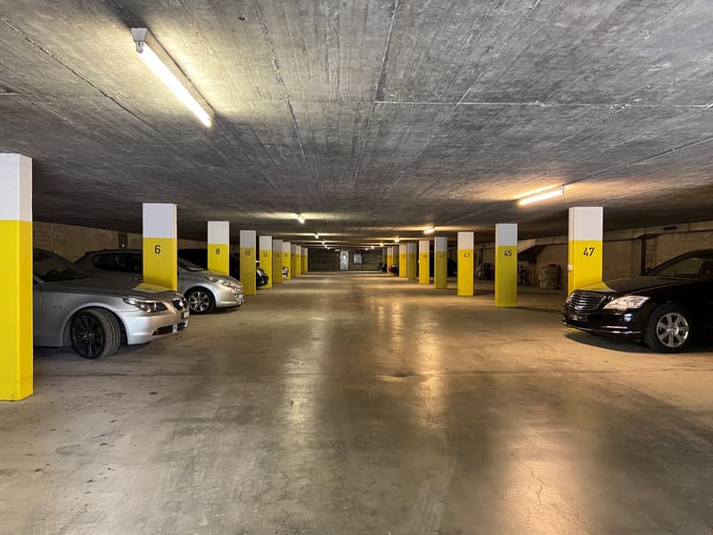 spacious underground parking with yellow pillars and lighting