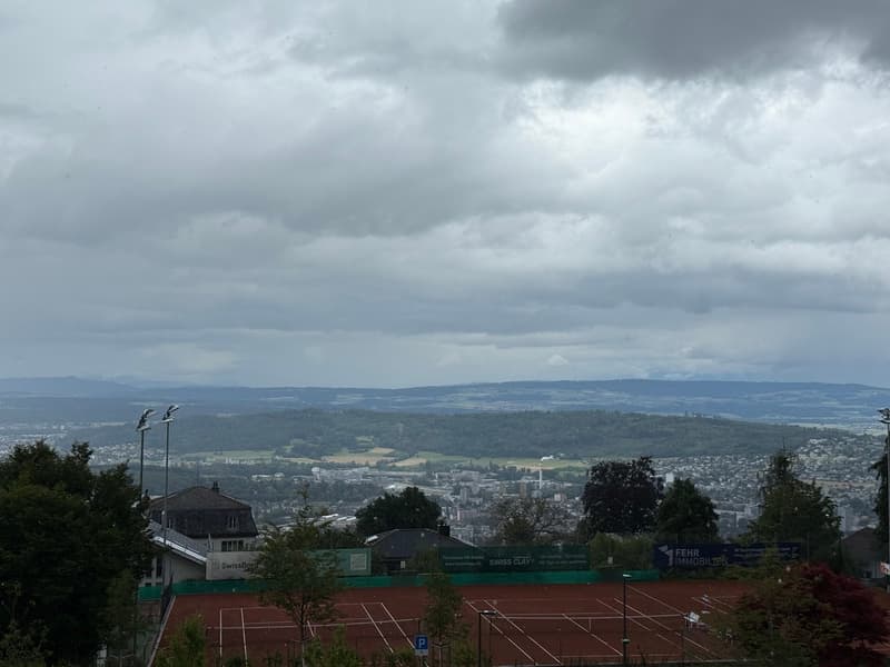 Tennis court, trees, mountains, cloudy sky, city view