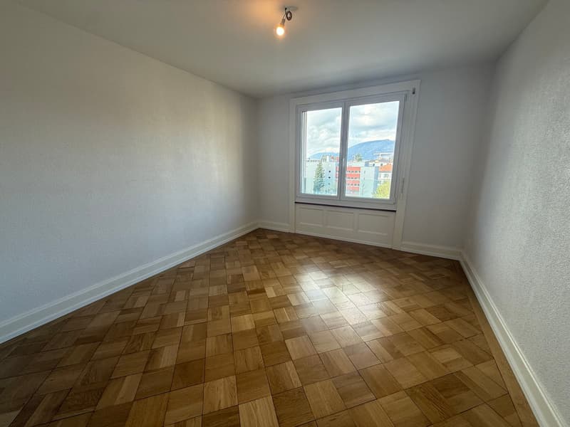 empty room, wooden parquet floor, large window, white walls, city view