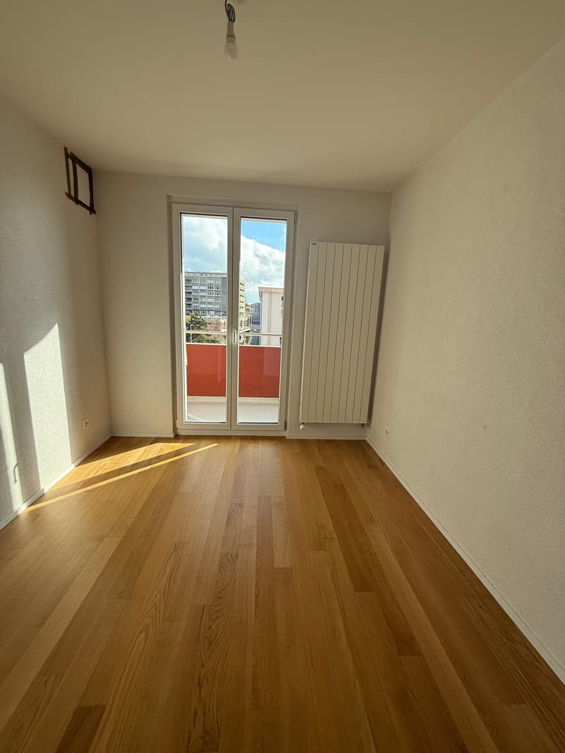 empty room, wooden floor, sliding glass door, white walls, white radiator, balcony