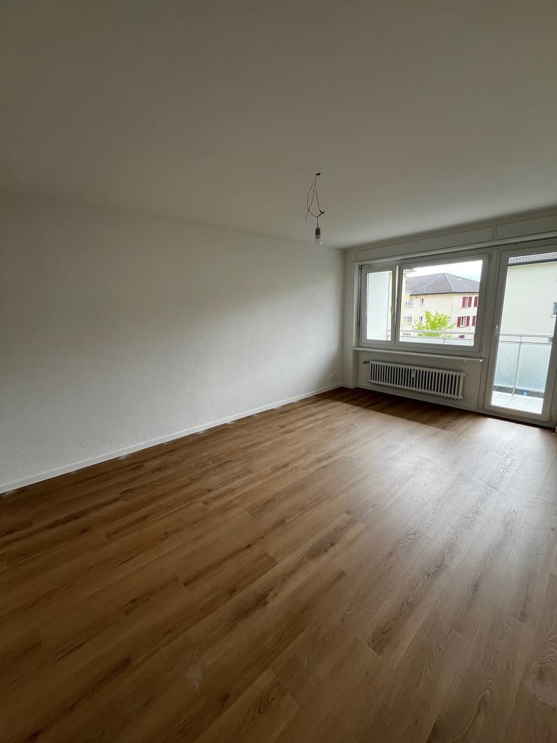 empty room, wooden floor, white walls, sliding glass doors, balcony, radiator
