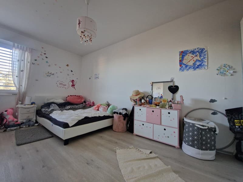 Bedroom with bed, cabinet, mirror, toys, rug, and decorations