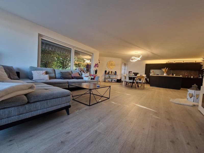 open plan living and dining area, large windows, wooden floor, modern furniture, coffee table, sofa, dining table and chairs, kitchen island
