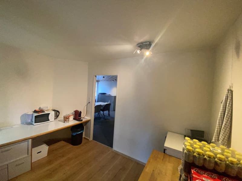 kitchenette area with microwave, kettle, toaster, drawers, desk, and a box of Coca Cola