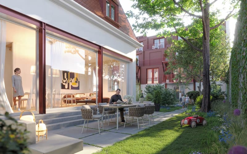 modern building, glass doors and windows, terrace with table and chairs, large backyard with grass and plants, children playing, toy car, red building in the background