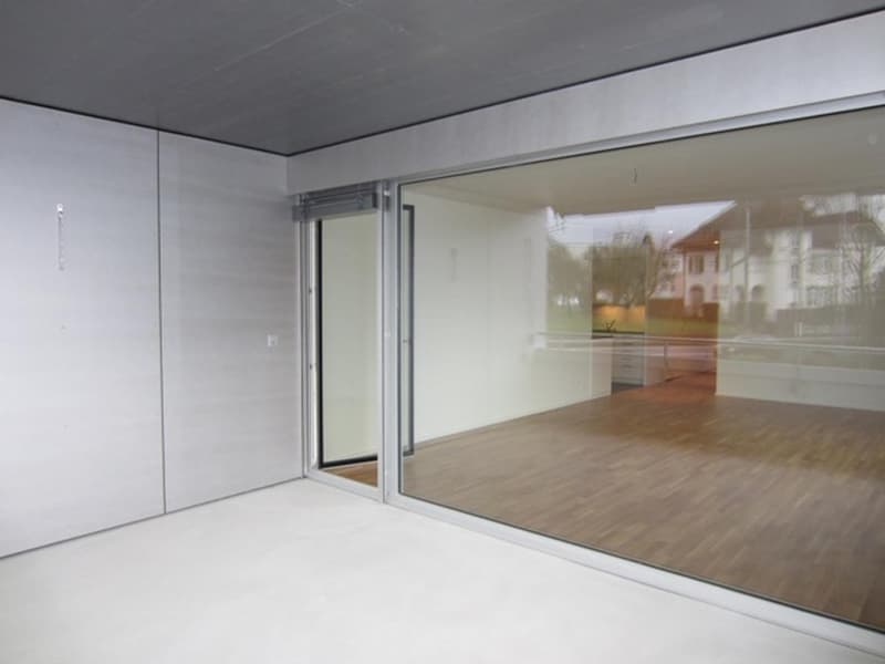 empty room, large glass windows, wooden floor, white walls, sliding glass door