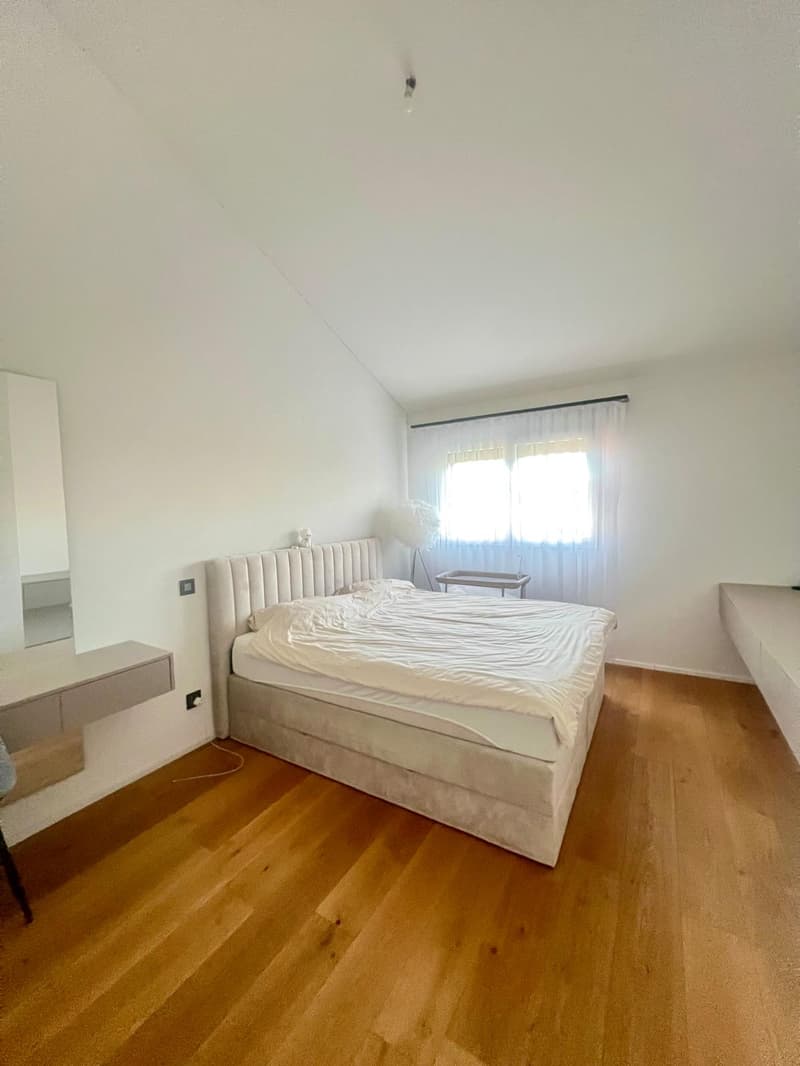 queen size bed, built-in wardrobe, white walls, wooden floor, window with curtains, bedside lamps