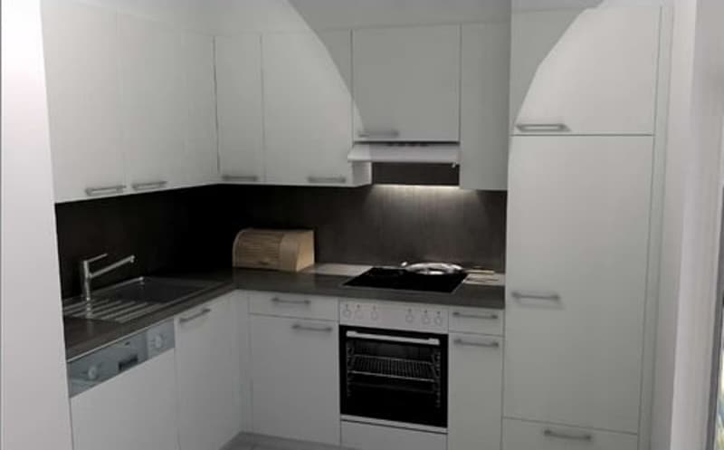 modern kitchen with white cabinets, black countertops, integrated dishwasher, oven, and sink with faucet