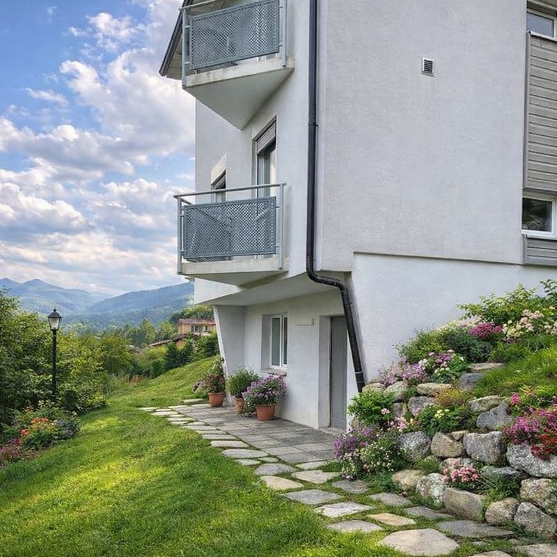 2 story house, white exterior, 2 balconies, stone pathway, garden with flowers, mountain view