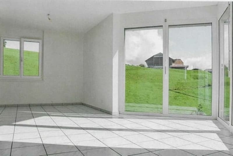 empty room, white walls, white tiles, large windows, sliding glass doors, view of a green field