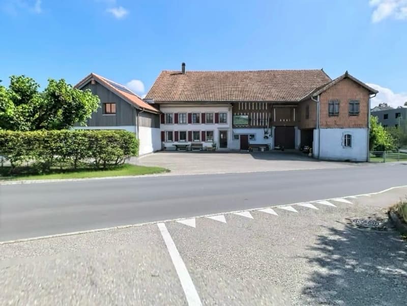 2 story house, brown roof, red shutters, solar panels, garage, driveway, hedges, trees