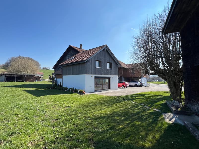 Detached house, brown roof, white walls, garage, cars parked in front, green lawn, trees