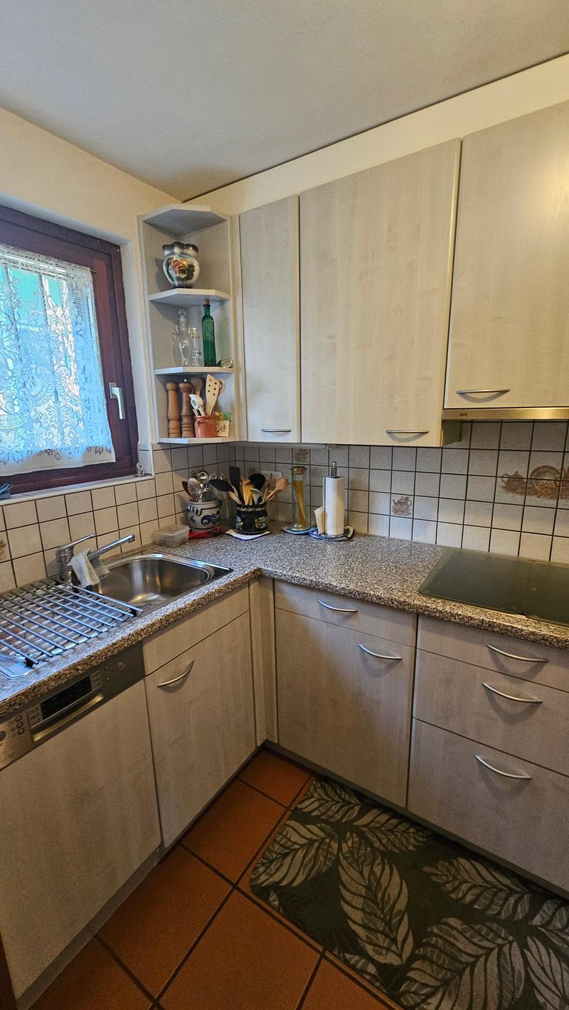 kitchen with sink, dishwasher, cabinets, countertop, window with curtain, tiled floor