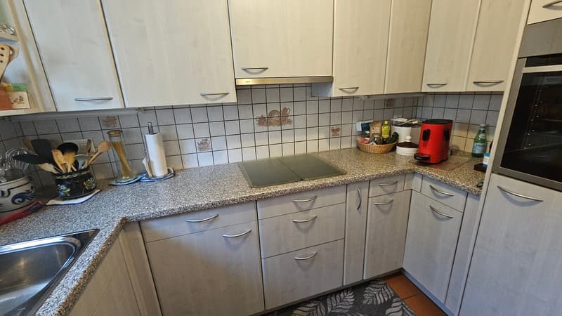 white cabinets, granite countertop, stainless steel sink, induction cooktop, built-in oven, dishwasher, washing machine