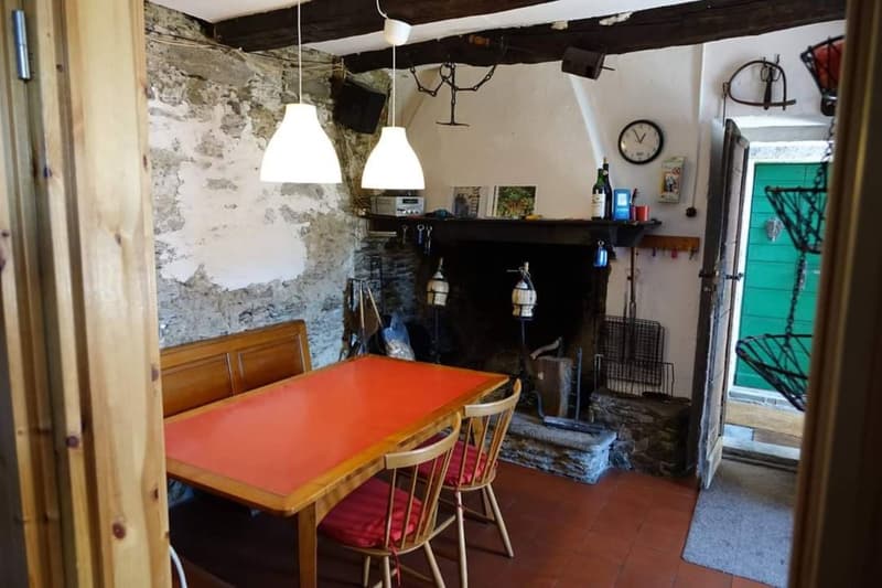room with dining table, chairs, fireplace, wooden benches, rustic wall, clock