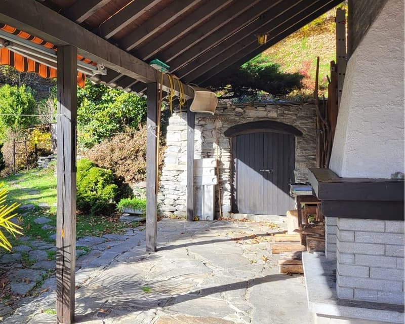 covered patio, stone wall, fireplace, wooden door, wooden beams, stone floor