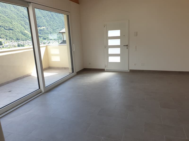 Large sliding glass doors, balcony, white walls, gray tiled floor, no furniture, view of mountains