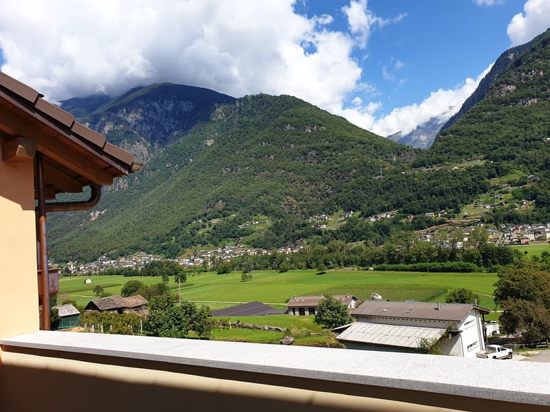 Overlooking green valley, mountains, houses, farm