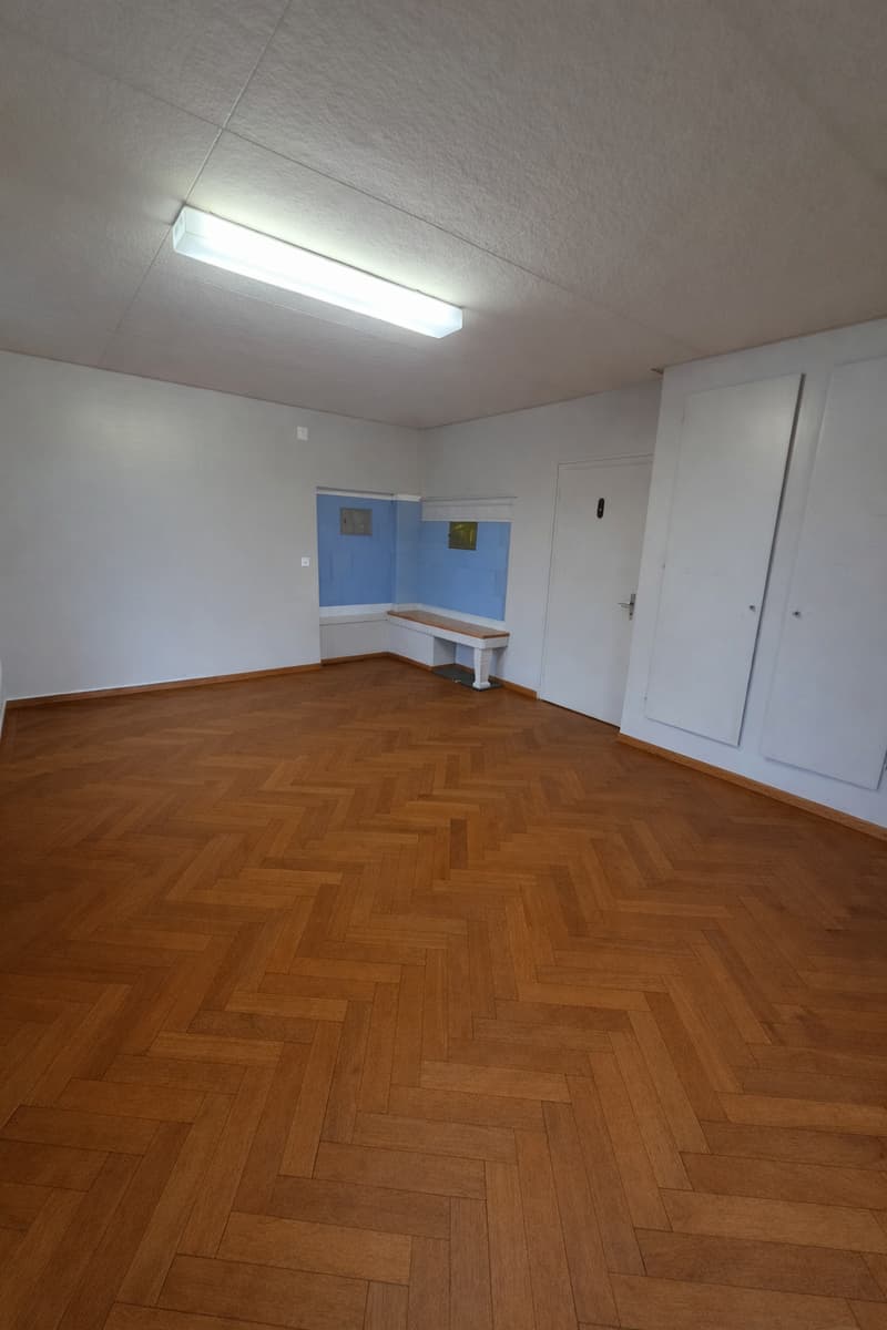 empty room, hardwood floor, white walls, bench, entrance door, bench with backrest, recessed lighting, white ceiling