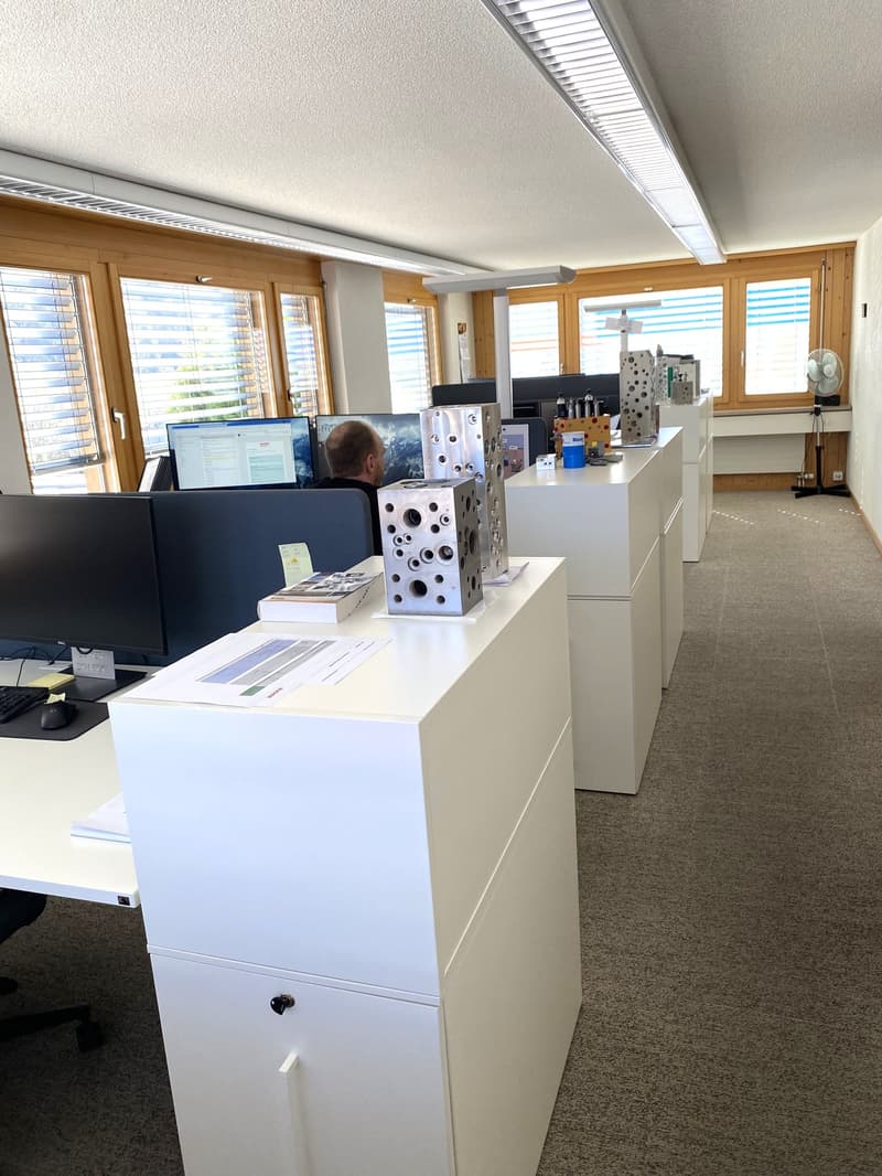 modern office with white desks, monitors, and office equipment
