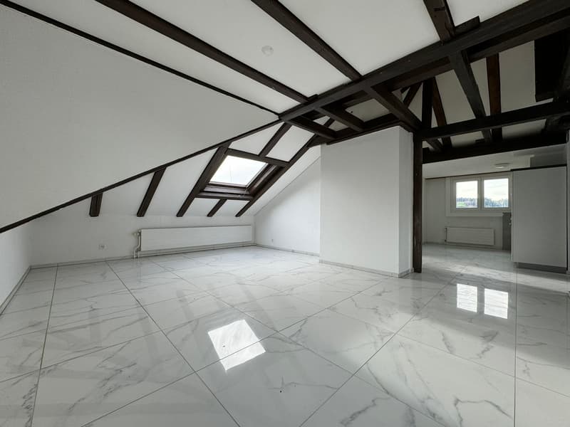 an attic room with a white tiled floor, dark wooden beams on the ceiling, skylights, a white pillar and a heater