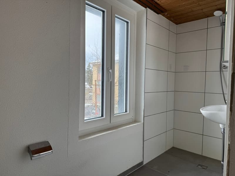 Bathroom with white tiles, window, sink, and shower