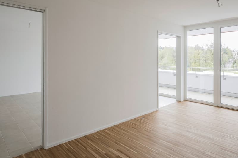 empty room, white walls, wooden floor, sliding glass doors, balcony, view of trees