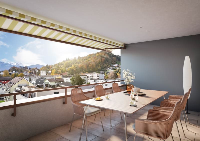 Balcony with dining table, chairs, and a view of the town and mountains