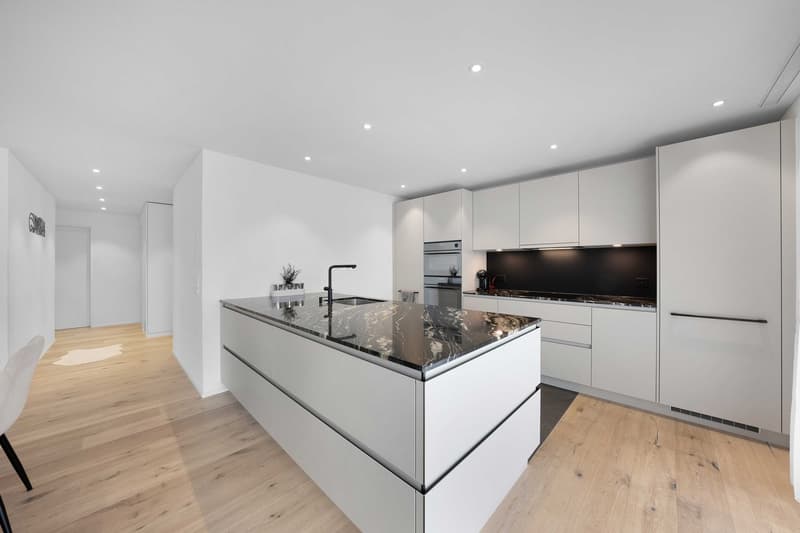 modern kitchen with white cabinets, marble countertop, black faucet, built-in oven, wooden floor