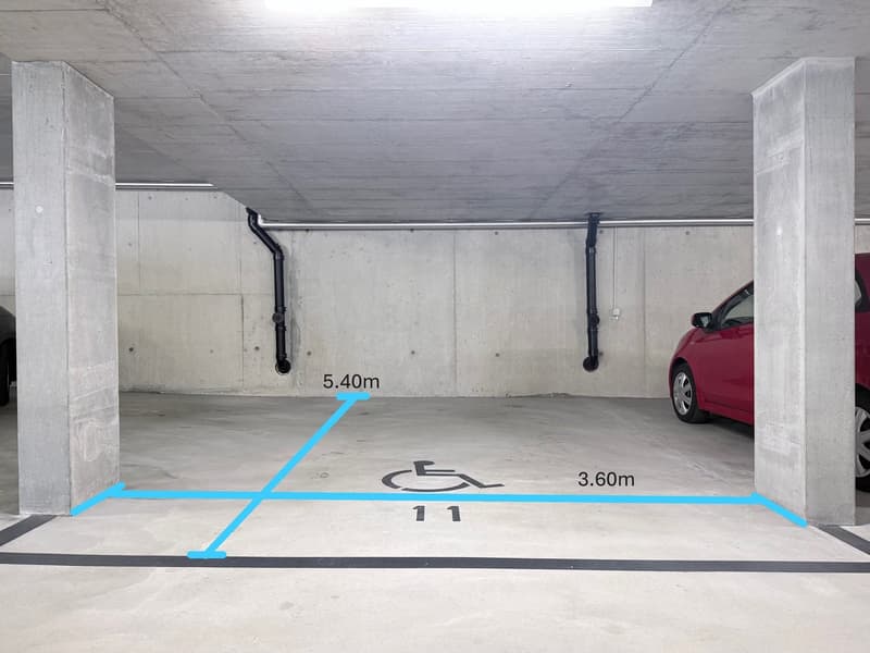 Underground parking garage with a car, measurements indicated, and accessible parking symbol