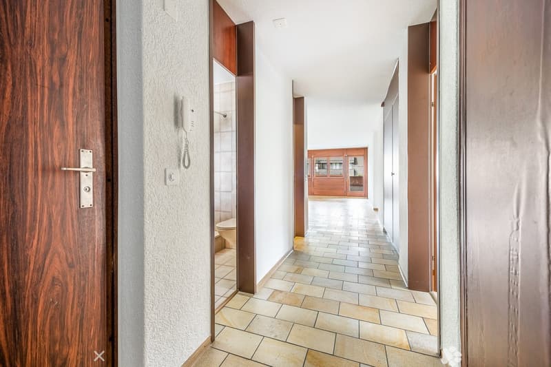 tiled floor, wooden doors, white walls, phone, open bathroom, light