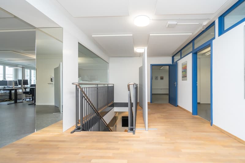 wooden flooring, glass wall, black railings, white ceiling