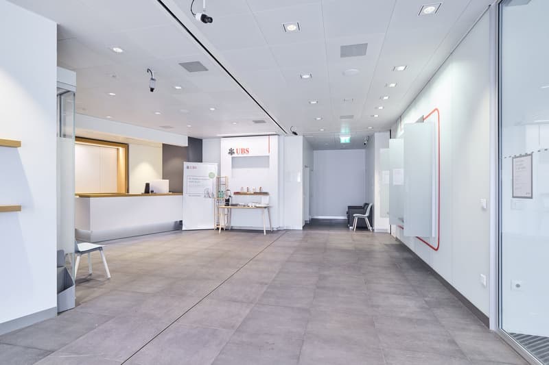 modern architecture, bright walls, large open space, white tile flooring, white desk, glass walls, empty room