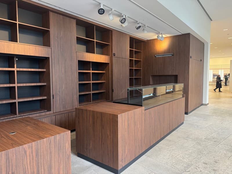 wooden shelves, glass display counter, tiled floor, track lighting