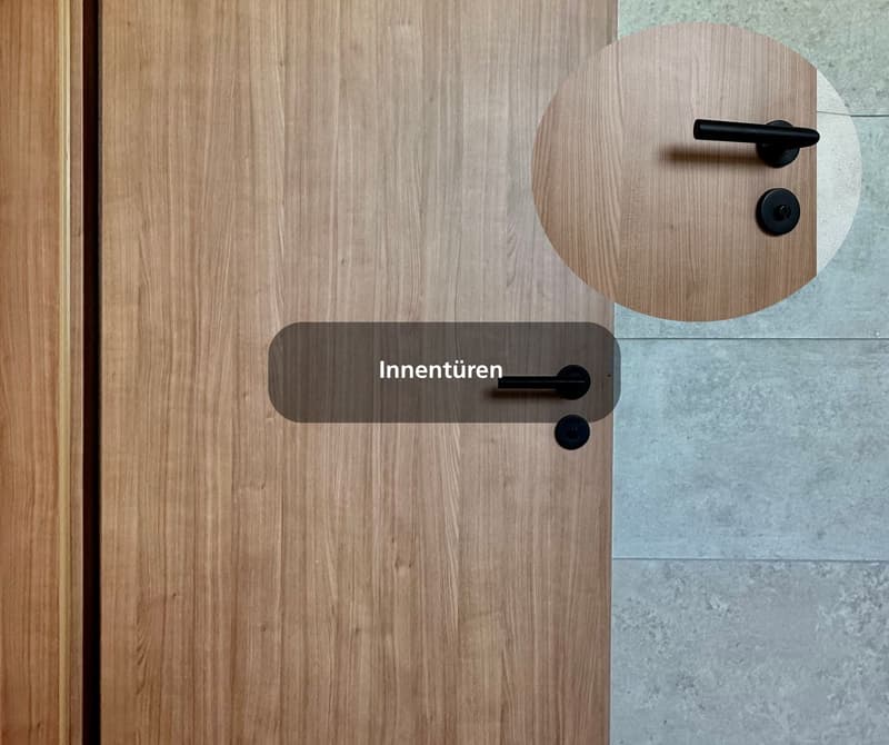 The image shows a wooden door with a round door handle and a keyhole, a black border on the bottom half of the door, and a tiled background.