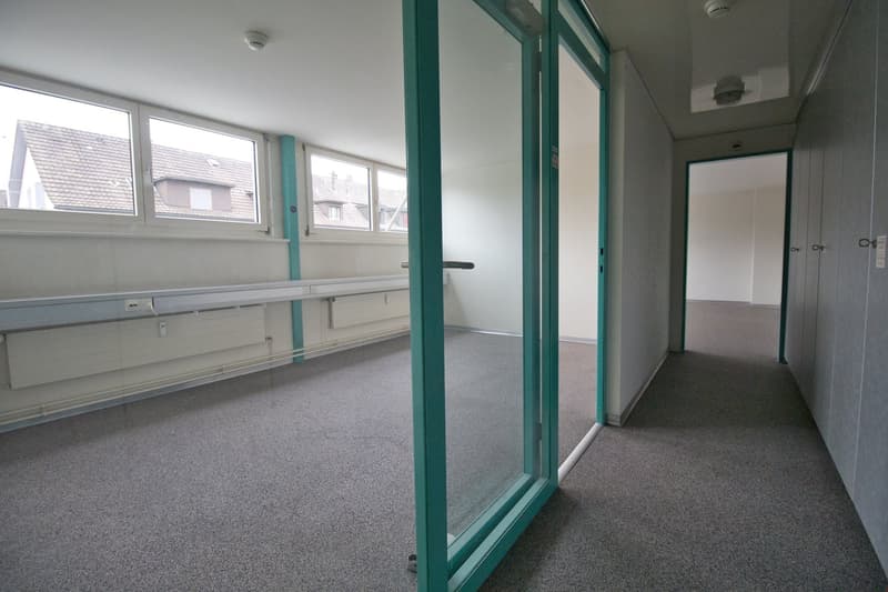 empty room, gray carpet, glass doors, windows, white walls, radiators
