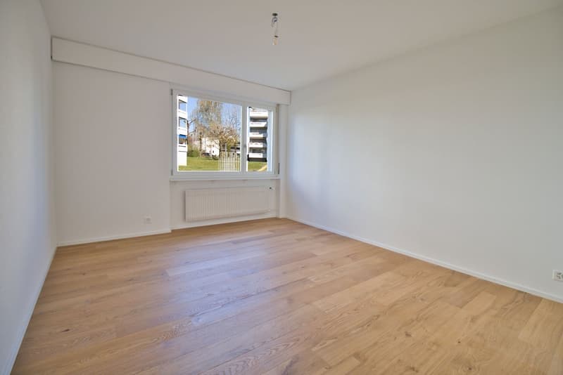 empty room, white walls, wooden floor, large window, white radiator