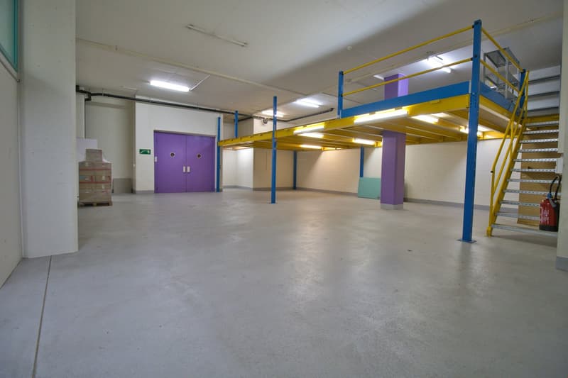 Empty room with concrete floor, metal shelves, and a fire extinguisher