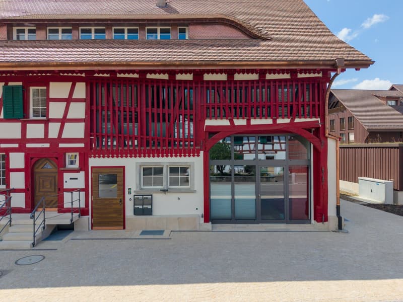 2 story house, red and white facade, brown roof, wooden doors, glass entrance, steps leading up
