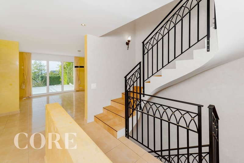 white walls, yellow floor, black railings, spiral staircase, glass doors