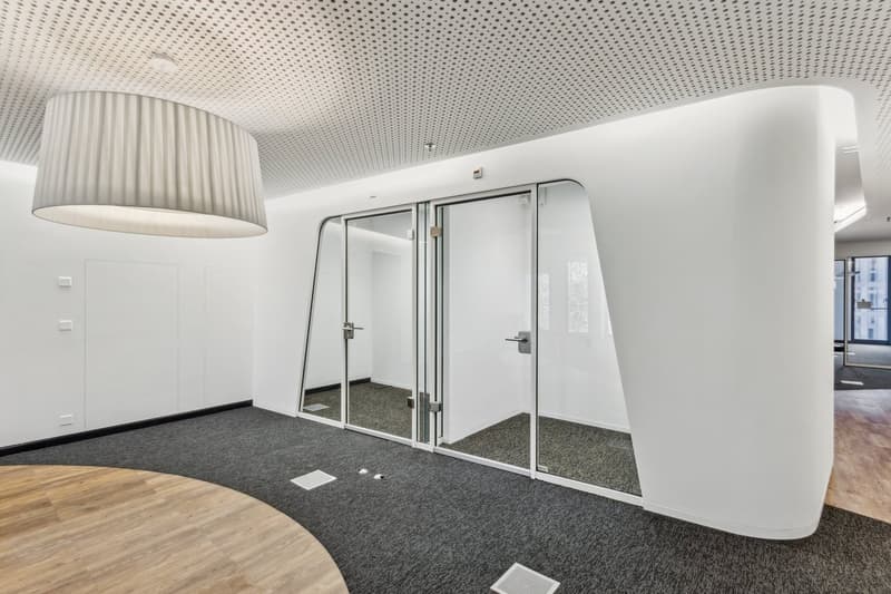 Contemporary design, minimalist decor, large glass doors, round table, wooden flooring, smooth white walls, perforated ceiling