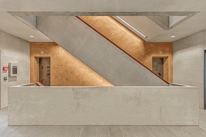 Concrete walls, wooden floor, concrete counter, stairs, golden wall, exit signs