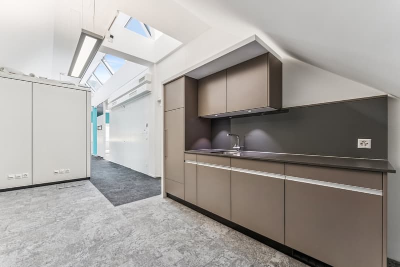 modern kitchen with gray cabinets, white walls, gray floor, skylights, sink, faucet, power outlet