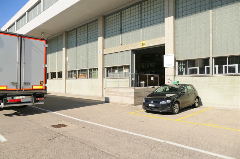 Concrete exterior, steel handrail, glass doors, loading bay, yellow parking lines