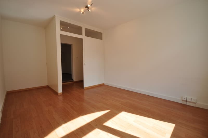 empty room, wooden floor, white walls, ceiling lights, door, power outlets