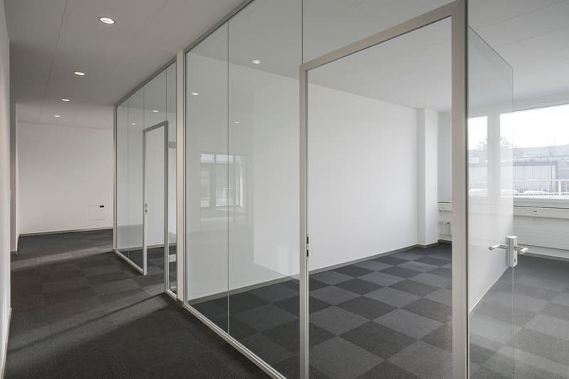 Empty room with glass walls and checkered tiles floor, ceiling with multiple lights