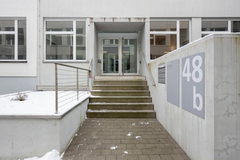 white building, glass windows, double entrance door, brick path, staircase, snowy ground