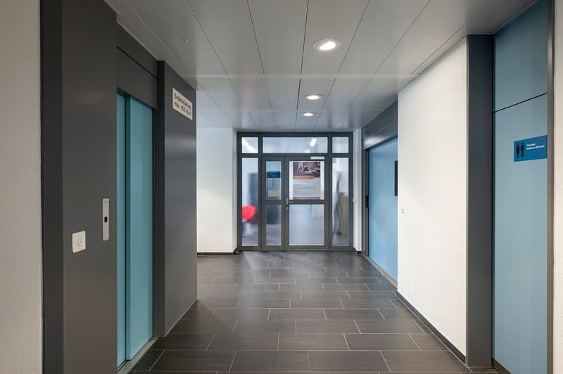 tiled floor, white and blue walls, glass doors, signs on wall