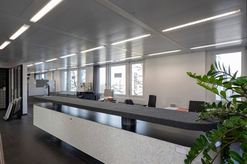 modern office, white walls, black tiled floor, black reception desk, large windows, black chairs, lamps