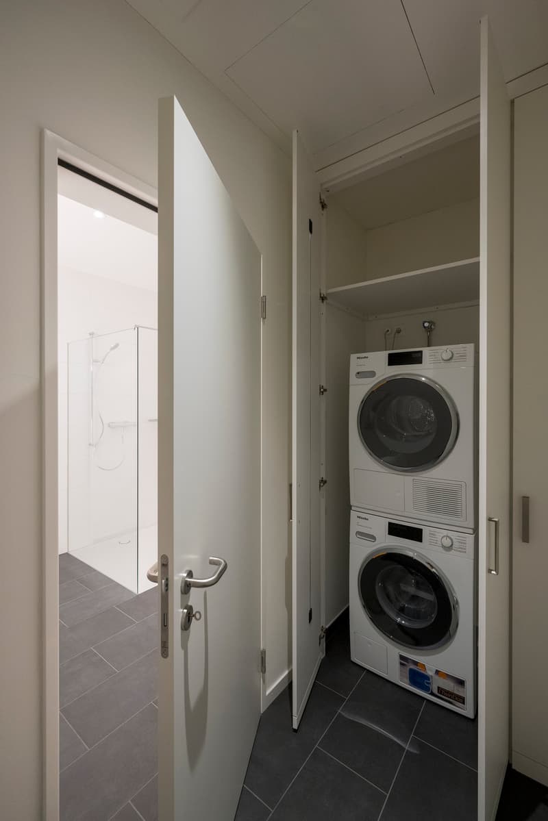 open door, washing machine and dryer, tile floor, adjacent to shower room